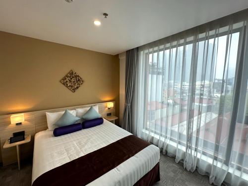 a bedroom with a bed and a large window at Hotel Yah Hanoi & Spa in Hanoi