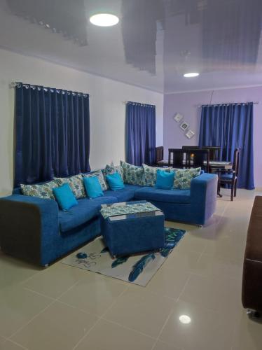 sala de estar con sofá azul y almohadas azules en Coral, en Fantino