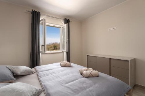 ein Schlafzimmer mit einem großen Bett und einem Fenster in der Unterkunft Holiday house Leana in Pazin