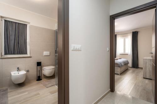 ein Bad mit einem WC, einem Waschbecken und einem Bett in der Unterkunft Holiday house Leana in Pazin