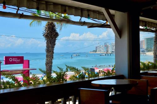 a view of the beach from a restaurant window at Chescos Hotel & Hostel in Salinas