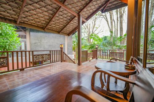 a porch with a table and chairs on it at มนต์เมืองเชียงใหม่ รีสอร์ต Monmuang Chiangmai Resort in Hang Dong