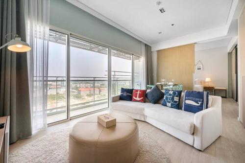a living room with a white couch and a large window at Veranda Residence/2BRFamilySuite in Na Jomtien