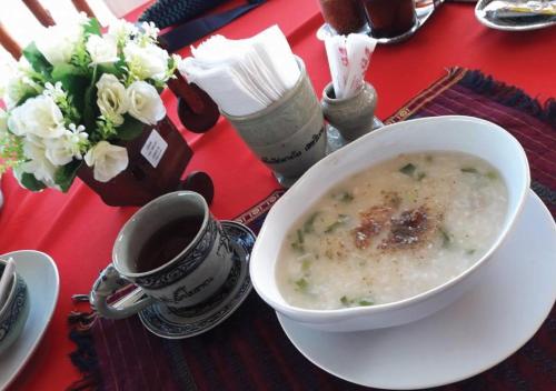 un tazón de sopa y una taza de café sobre una mesa en Sisatchanalai Heritage Resort, en Si Satchanalai