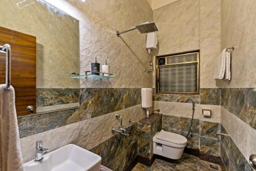 a bathroom with a sink and a toilet at SaffronStays Mango Lakeview Villa, Nashik in Nashik
