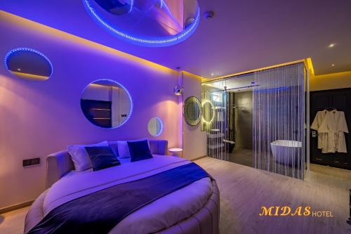 a purple bedroom with a large bed and a bathroom at Midas Hotel in Ho Chi Minh City