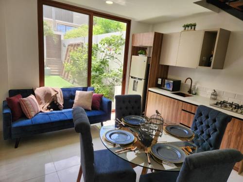 a living room with a blue couch and a table at Lujo, mar, seguridad y diversión en la mejor zona de Manta. in Manta