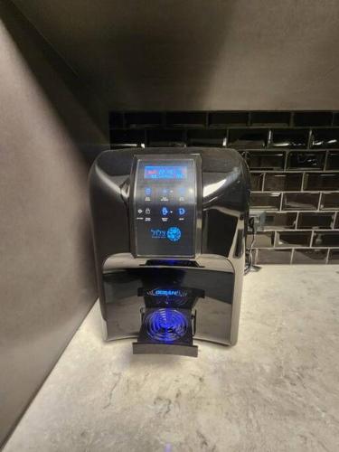 a coffee machine with a bluevisorvisor on top of it at מבנים בים 75 Suites at sea in Haifa