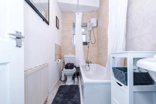 e bagno con servizi igienici, vasca e lavandino. di 65 Inch TV & Luxurious 2 Bedroom Suite for Your Ultimate Getaway a Bradford
