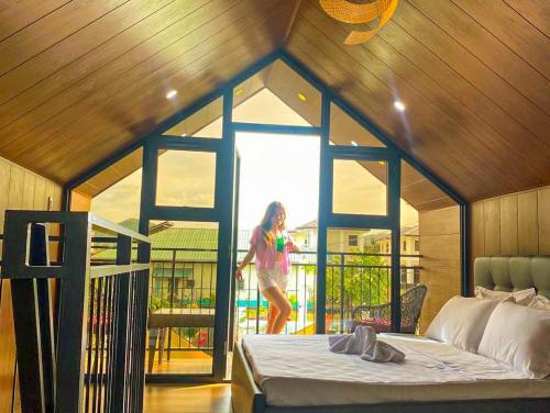 Una chica está caminando en una habitación con una cama en Hidden Haven Subic Villa w/ Infinity Pool, en Subic