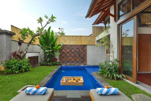 a pool in the backyard of a house with a pool table at Teratai Villa Canggu by Ini Vie Hospitality in Canggu