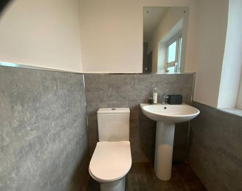 a bathroom with a white toilet and a sink at Warm and cosy city centre home near train station in Chichester