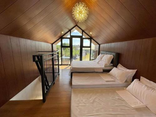 Habitación con 2 camas y lámpara de araña. en Hidden Haven Subic Villa w/ Infinity Pool en Subic