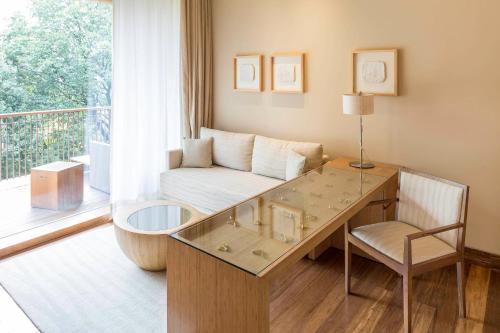 a living room with a table and a couch at Six Senses Vana - A Wellness Retreat in Dehradun