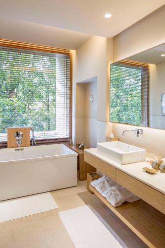 a bathroom with a large tub and a large window at Six Senses Vana - A Wellness Retreat in Dehradun