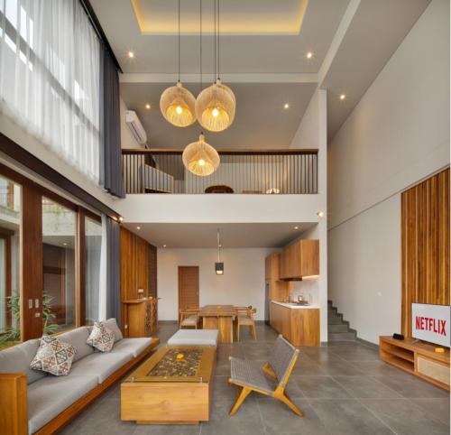 a living room with a couch and a table at Teratai Villa Canggu by Ini Vie Hospitality in Canggu