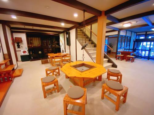 a room with a table and chairs and stairs at Hakuunsou in Takayama