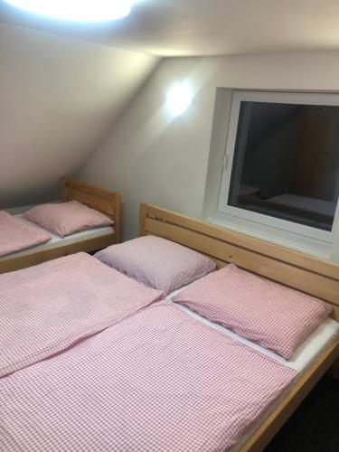 two beds in a room with a flat screen tv at Apartmány u vleku - Podkrovní apartmán in Karlova Studánka