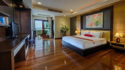 um quarto de hotel com uma cama e uma televisão em Koh Samui Tower em Mae Nam
