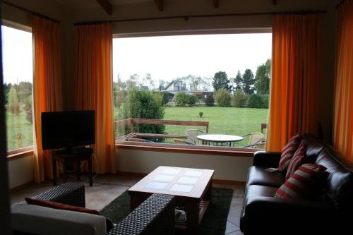 a living room with two couches and a large window at Cabañas Portal de las Rosas in Puerto Varas