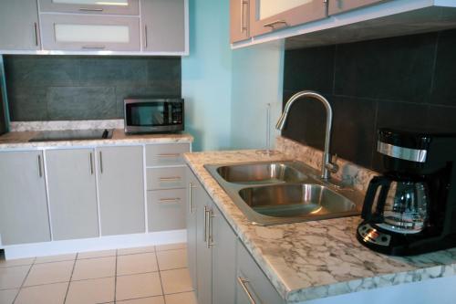 a kitchen with a sink and a microwave at MAVS COMBATE BEACH CLUB in Cabo Rojo