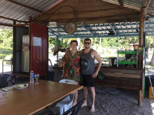 a man and a woman standing in front of a table at Wild Pasir Panjang in Kuah
