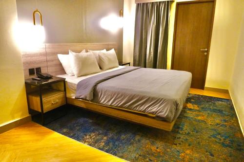 um quarto com uma cama com uma mesa-de-cabeceira e uma cama sidx sidx em Series Hotel Sudirman em Jakarta
