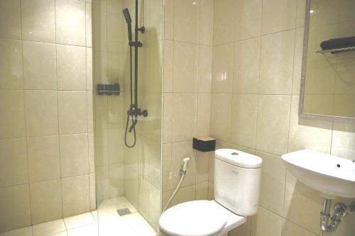 uma casa de banho com um chuveiro, um WC e um lavatório. em Series Hotel Sudirman em Jakarta