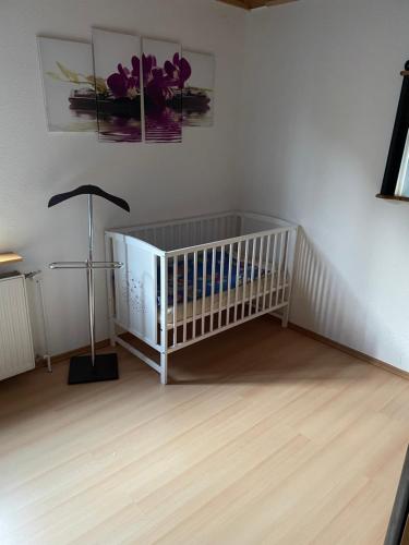a nursery with a crib and a lamp in a room at Jeanny´s Ferienwohnung in Thale