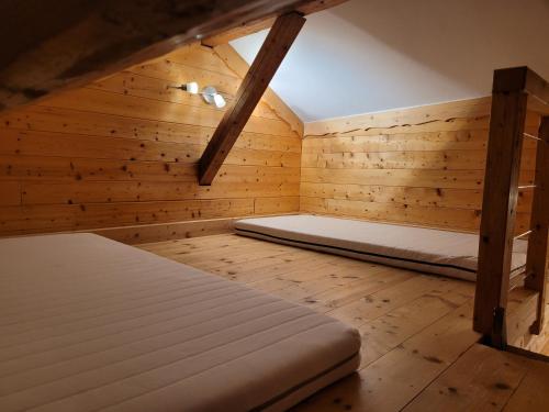 a bedroom with two beds in a wooden room at 7 p - Au cœur du massif jurassien in Les Rousses