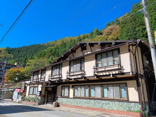 un bâtiment avec des balcons sur le côté d'une montagne dans l'établissement Hakuunsou, à Takayama