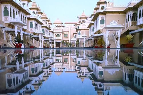 a courtyard of a building with a reflection in the water at Hotel Gautam Lonavala in Lonavala