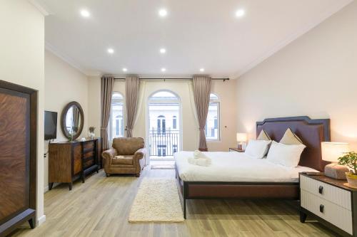 a bedroom with a large bed and a chair at L'amour Villa with Sauna at City Center in Da Nang