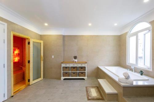 a large bathroom with a tub and a window at L'amour Villa with Sauna at City Center in Da Nang
