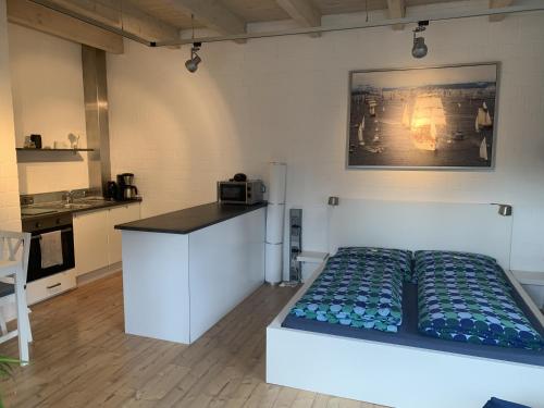 um quarto com uma cama e uma cozinha em Apartment Reetblick em Kiel