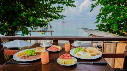 una mesa con platos de comida encima en Lipe Garden Beach Resort, en Ko Lipe