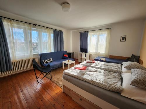 - une chambre avec un lit, une chaise et un canapé dans l'établissement Penzion Sport, à Třeboň