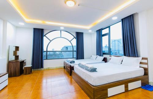 1 dormitorio con 2 camas y ventana grande en Hoa Cúc Phương Hotel Dĩ An - Bình Dương en Dĩ An