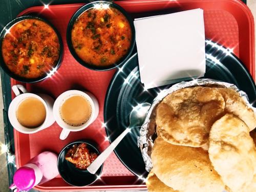 a lunch box with food and coffee and a plate of food at Hotel celebration in Alwar