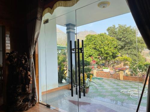 una puerta de cristal abierta con vistas al jardín en Ori Villa Mộc Châu en Mộc Châu