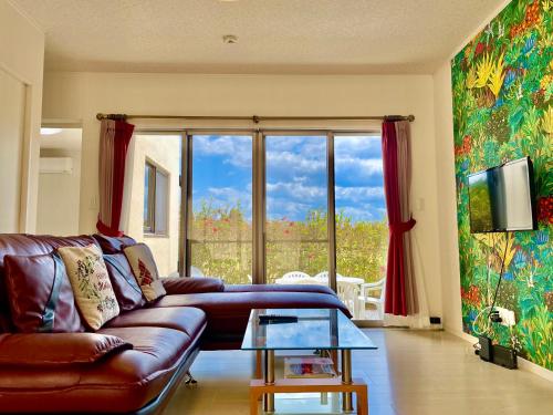 名護的住宿－RB Villa Sumuide，带沙发和大窗户的客厅