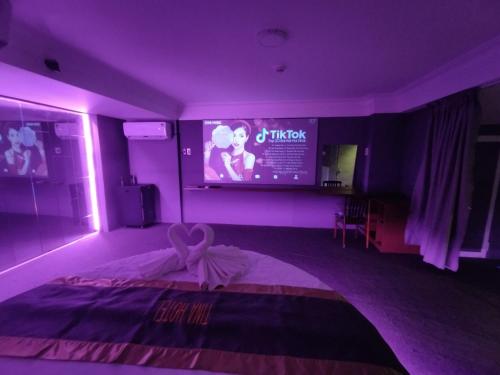 a purple room with a bed and a tv at Tina 2 Hotel in Cái Răng