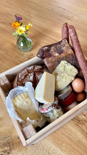 a plastic container filled with different types of cheese and meats at Almdorf Omlach, Fanningberg in Weisspriach