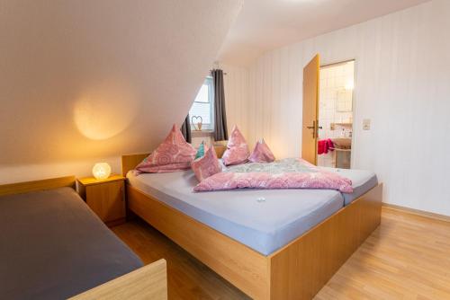 a bedroom with two beds with pink pillows at Heidetraum Pension & Ferienwohnung Arndt in Bispingen