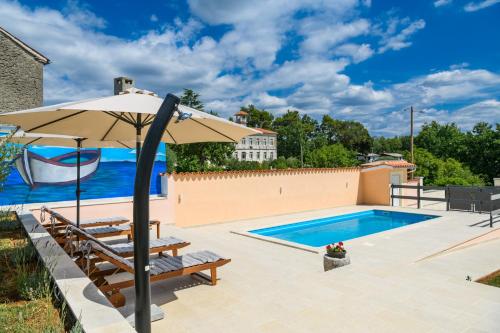 a patio with an umbrella and a swimming pool at House Angela with private pool, private parking, wi-fi and fully fenced garden - WiiBuk in Divšići