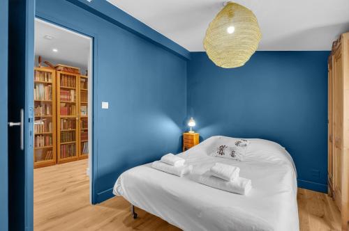 - une chambre bleue avec un lit et des serviettes dans l'établissement Tré-Canela - Proche centre ville, à Toulouse