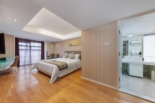ein großes Schlafzimmer mit einem Bett und einem Badezimmer in der Unterkunft Sunflower Hotel & Residence, Shenzhen in Shenzhen