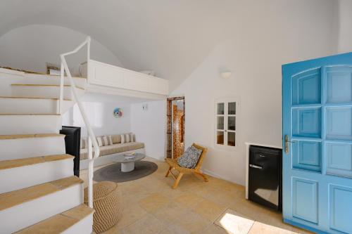 a room with a staircase and a blue door at Nano Oia Villas in Oia