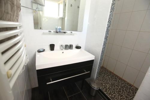 bagno con lavandino bianco e specchio di Chambres d'hôtes - Villa CARPE DIEM TOLOSA a Vieille-Toulouse