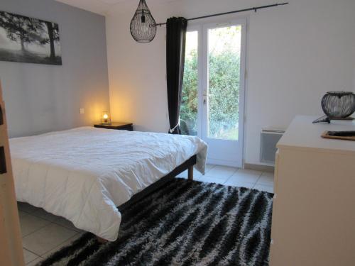 une chambre avec un lit et une grande fenêtre dans l'établissement Villa avec Terrasse, Spa et Proximité Plages - FR-1-194-256, à La Faute-sur-Mer